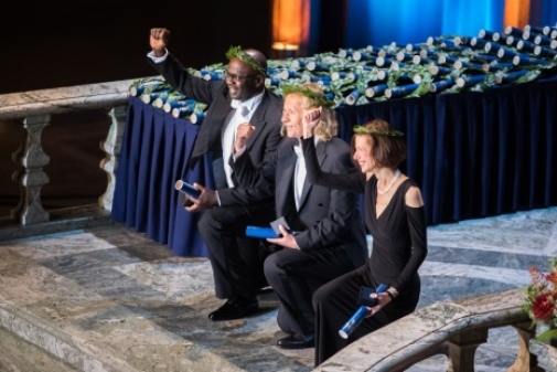 De tre hedersdoktorerna Lilian Thuram, Ansgar Nünning och Susan Faludi gör en knäprotest vid Stockholms universitets installations- och promotionshögtid i Stadshuset. Foto: Niklas Björling
